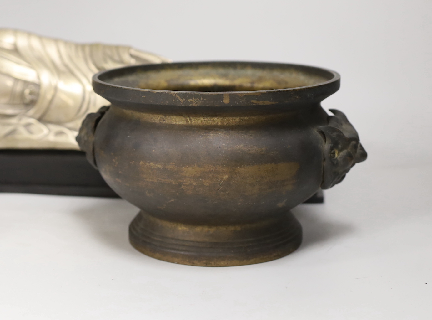 A Chinese silvered metal reclining Buddha and a two handled censer, reclining Buddha 41cm wide